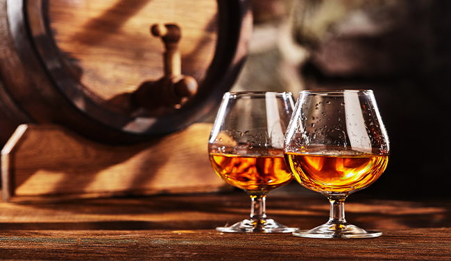 Glass of brandy with a barrel