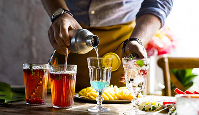 A bartender mixing colorful cocktails