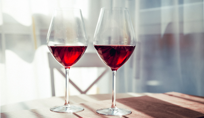 A glass of red wine being poured