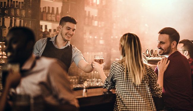 Crowded ar with bartender taking drink order