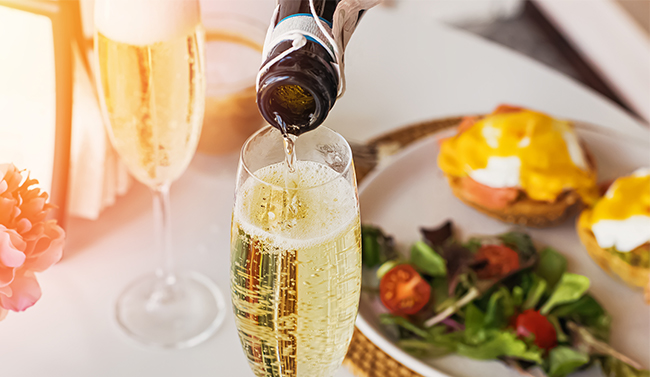 A bottle of Champagne being poured into a glass