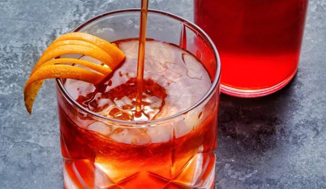 Orange cocktail with a bottle of liqueur